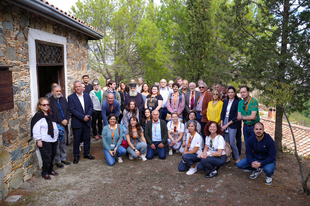 group picture of the TExTOUR consortium taken in front of the church of the village of Fikardou during a site visit